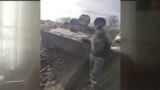 Тәжік мигранты Кәрім Украинаның Ресей оккупациялаған Запорожье облысында танк алдында суретке түсіп тұр. 2022 жылғы қараша.