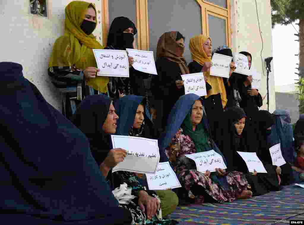 Afghan women hold placards reading in Dari &quot;A Muslim can&#39;t be against women&#39;s education and work,&quot; during a protest as they demand their right to education and work in Mazar-e-Sharif, Afghanistan.