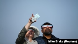 Ljudi koriste solarne naočare za posmatranje pomračenja Sunca u zalivu Depo, Oregon, SAD, 21. avgusta 2017.