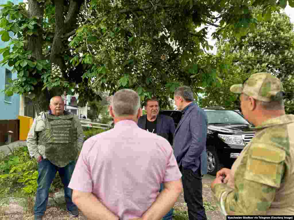 A man wears an armored vest as Belgorod Governor&nbsp;Vyacheslav Gladkov (in blue jacket) meets residents near where fighting took place.&nbsp; Leaders of the anti-Kremlin Russian militants say cross-border raids are intended to inspire Russians to rise up against their government.