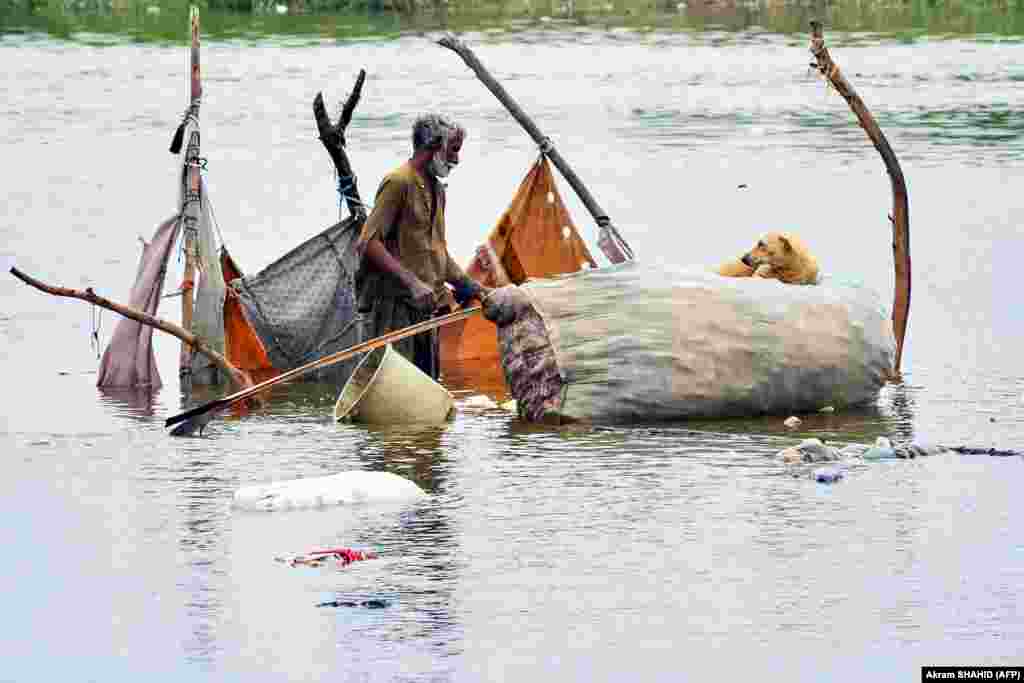 A man gathers his belongings from a bamboo tent, partially submerged in floodwaters, after heavy monsoon rains in Hyderabad, Sindh Province. Authorities have warned that ongoing heavy rain, which began last month, could cause landslides and flash floods across Pakistan. &nbsp;