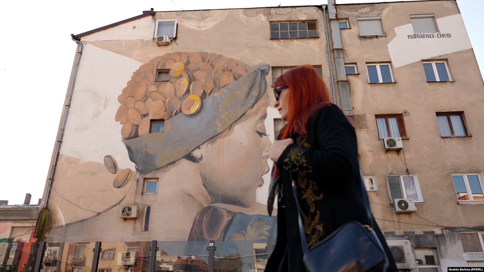 Lebibe Topalli duke kaluar pranë muralit që ka pikturuar vetë në Ferizaj.