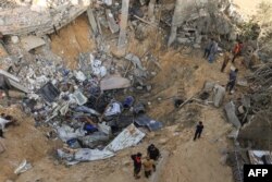 Palestinci stoje uz rub kratera nakon izraelskog bombardiranja Rafe na jugu Pojasa Gaze, 10. novembra