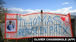 Транспарент на кој пишува „Томас, почивај во мир“ во Романс-сур-Изер, град на југот на Франција, во чест на убиениот тинејџер. Томас им подлегна на повредите во инцидентот на 19 ноември, а истрагата за случајот сѐ уште е во тек