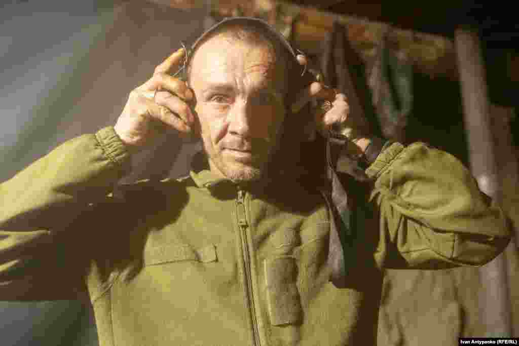 Олег одягає активні захисні навушники перед виходом на бойову роботу. Херсонщина. Березень 2024 року
