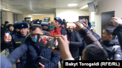 Журналист Сайпидин Султаналиевди милиция кызматкерлери сотко алып келе жаткан учур. 17-январь, 2022-жыл.