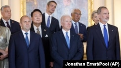 U.S. President Joe Biden (front center) and Hungarian Prime Minister Viktor Orban (back left) -- along with other European leaders -- attend a NATO event in Madrid in June 2022. Biden has excluded Orban from the list of invitees to his Summit for Democracy twice: in 2021 and this week.