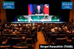 Президент РФ Владимир Путин (на экране) во время выступления на заседании XXV Всемирного Российского народного собора в Кремлевском дворце. Москва, 28 ноября 2023 года