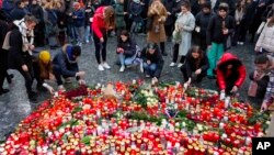 Люди несуть свічки і квіти до будівлі Карлового університету в Празі, де сталася стрілянина
