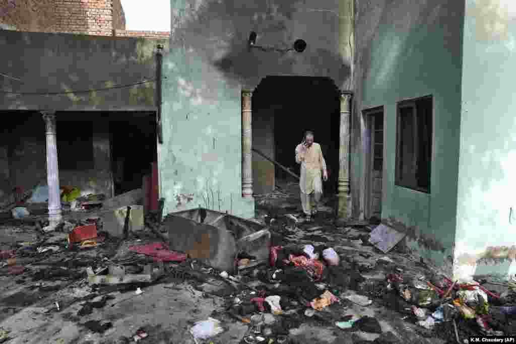 A Christian man looks through the debris of a home vandalized in the town of Jaranwala outside the eastern Pakistani city of Faisalabad on August 17 after it was ransacked by an angry mob.