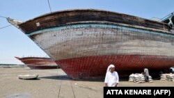 <div>A man walks in front of a traditional Iranian lenj boat that awaits restoration on Iran's Qeshm Island on April 29. The silhouette of these hand-built wooden vessels is as much a part of the maritime landscape of the Middle East as that of the sailing dhows of the Arabian Peninsula.</div>
<div> </div>