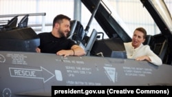 Președintele ucrainean Volodimir Zelenski și premierul danez Mette Frederiksen într-un avion de luptă F-16 fighter la baza aeriană Skrydstrup, Vojens, Danemarca, 20 august 2023. 