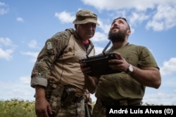 Yuriy (right) learns to operate a newly acquired drone.