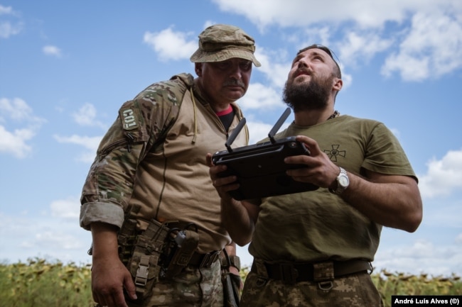 Yuriy (right) learns to operate a newly acquired drone.