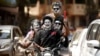 Момчета с боядисани лица карат мотоциклет по време на честването на древния индийски празник "Холи" в Мумбай, Индия, 25 март 2024 г.