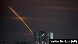 Rockets launched from Russia's Belgorod region streak across the sky at dawn in Kharkiv, Ukraine, early on March 24.