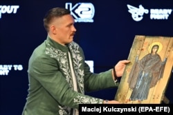 Александр Усик держит икону во время пресс-конференции во Вроцлаве, Польша, 24 августа 2023 год