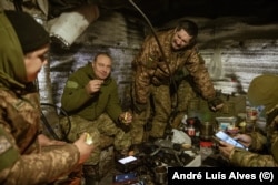 Ukrainian soldiers relax in a dugout in the Donetsk region.
