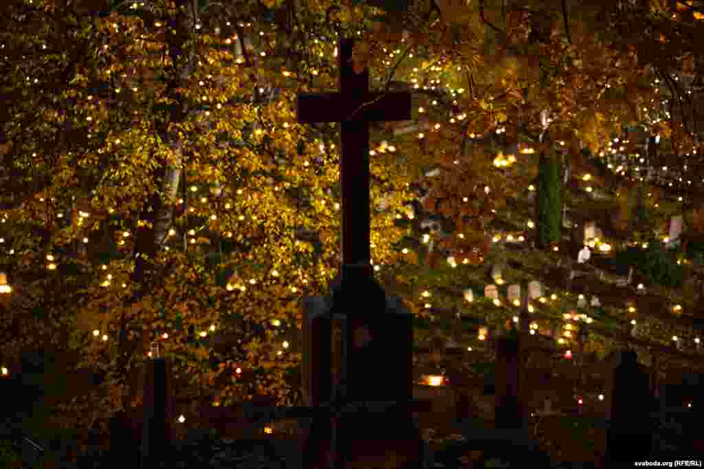A cross surrounded by autumn leaves and candles.&nbsp; For many Belarusians in Lithuania the Rasos Cemetery, where many notable ethnic Belarusians are interred, has become a site to continue ancient traditions while paying respects to their forefathers.&nbsp;