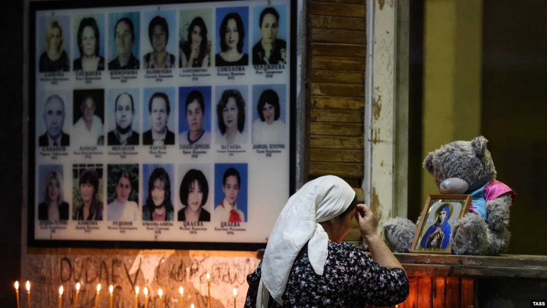 O femeie se închină pe 1 septembrie 2023 la un eveniment de comemorare a 19 ani de la criza ostaticilor de la Școala nr. 1 din Beslan, la 20 km nord-vest de orașul Vladikavkaz, în Osetia de Nord, Rusia.