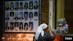 O femeie se închină pe 1 septembrie 2023 la un eveniment de comemorare a 19 ani de la criza ostaticilor de la Școala nr. 1 din Beslan, la 20 km nord-vest de orașul Vladikavkaz, în Osetia de Nord, Rusia.