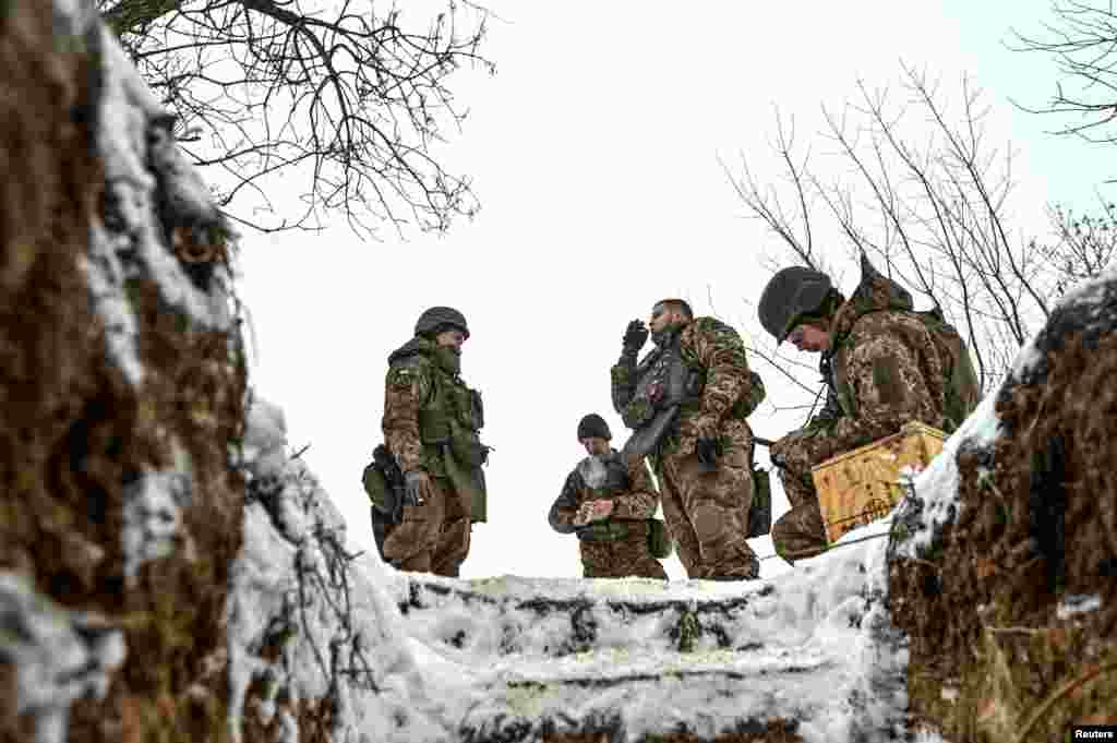 Disa ushtarë ukrainas tymosin cigare në një pozicion afër vijës së frontit në rajonin Zaporizhja, 14 janar 2024.