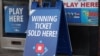 تابلوی یک فروشنده بلیط بخت‌آزمایی در شهر واشینگتن در روز ۲۶ تیرماه که روی آن نوشته شده است: «بلیط برنده این‌جا فروخته شده!»
