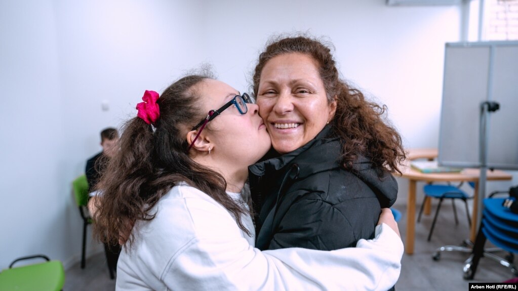 Ada, 17 vjeç, duke i dhuruar një përqafim nënës së saj, Nurten Gorda, pasi përfundoi punimin e kartolinave në shoqatën Down Syndrome Kosova në Prizren.