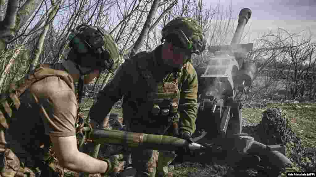 Ukrán katonák töltenek egy M119-es 105 mm-es ágyút