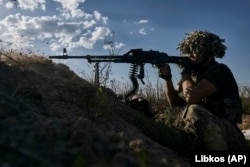 A Ukrainian soldier of the 53rd Brigade fires from a trench at the front line close to Donetsk on August 19.