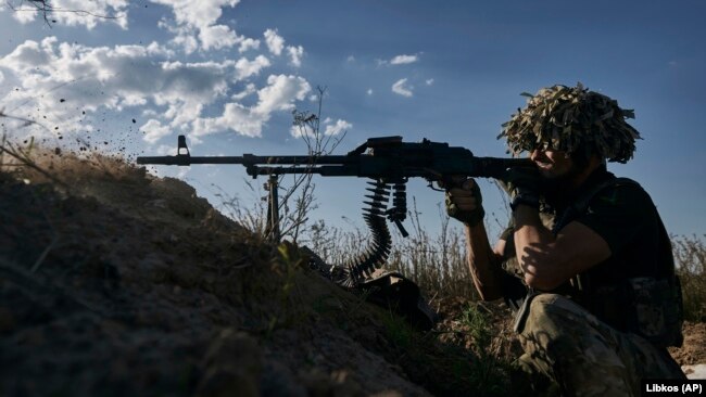 Украински войник от 53-та бригада стреля от окоп на фронтовата линия близо до Донецк, 19 август 2023 г.