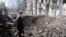 Мъж в Авдиивка оглежда нов кратер след руски обстрел в центъра на родния му град. Снимка: Якуб Лайхтер (©)