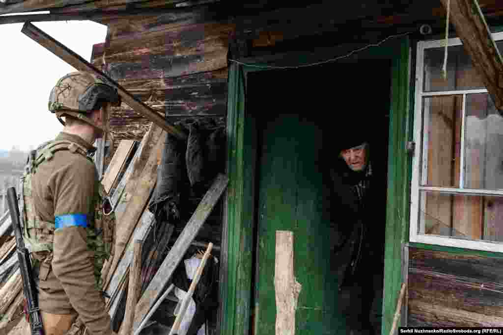 Fotografia e parë: Një zëdhënës i ushtrisë ukrainase duke bërë përpjekje për ta bindur Valentynin, banor 82-vjeçar i Teterivskes, për t&#39;u larguar nga shtëpia e tij, teksa artileria ruse nisi granatimin e fshatit. Fotografia e dytë: Shtëpia e braktisur e Valentynit. Pas evakuimit nga Teterivske, i moshuari ka vdekur paqësisht, i rrethuar nga familjarë. Shtëpia e tij tani po rinovohet.