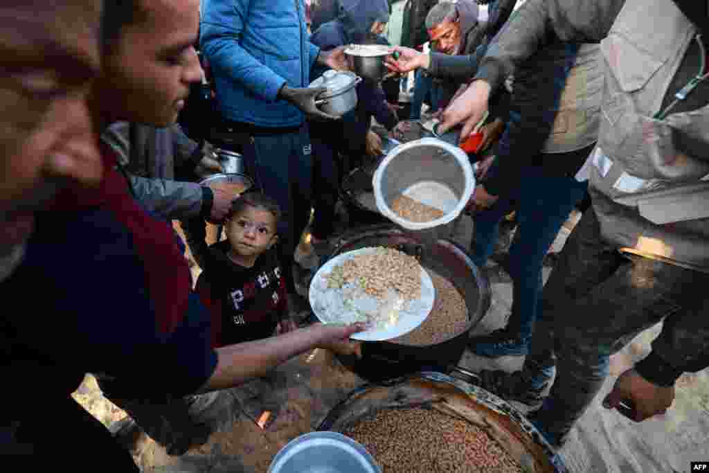 Палестинците добиваат храна донирана од добротворни организации, Рафа, 11 март.