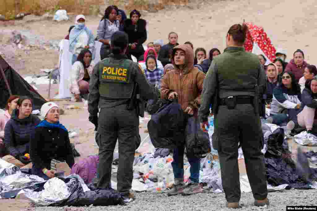 Pjesëtarë të Patrullës kufitare të SHBA-së, duke biseduar me emigrantë në kufirin me Meksikën, afër San Diegos, më 11 maj 2023.