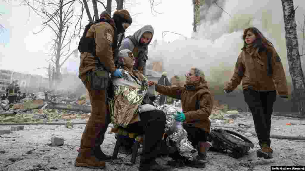 Medical workers treat a wounded resident. The missiles shattered hundreds of apartment windows in icy weather, Syniehubov said.