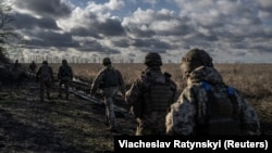Військовослужбовці 55-ї окремої артилерійської бригади ЗСУ йдуть на позиції біля Мар’їнки, Донецька область, 26 грудня 2023 року