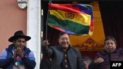 لوئیس آرسه، رئیس جمهوری بولیوی، در بالکن کاخ دولت پرچم بولیوی را تکان می‌دهد