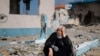 Žena pored oštećene zgrade u Rafi, u južnom pojasu Gaze, 15. februara 2024. 