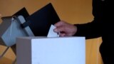 Voter in Bulgaria puts voting ballot in the box