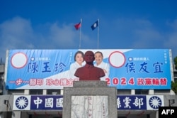 Статуя засновника республіки на Тайвані Сунь Ятсеня на тлі передвиборчих білбордів опозиційної партії Гоміньдан. Фото грудня 2023 року