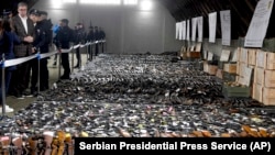 Serbian President Aleksandar Vucic (left) inspects weapons collected last month as part of an arms amnesty. (file photo)