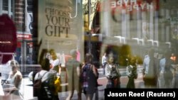 Vásárlók és dolgozók tükörképe egy üzlet kirakatában Sydney belvárosában 2014. március 6-án