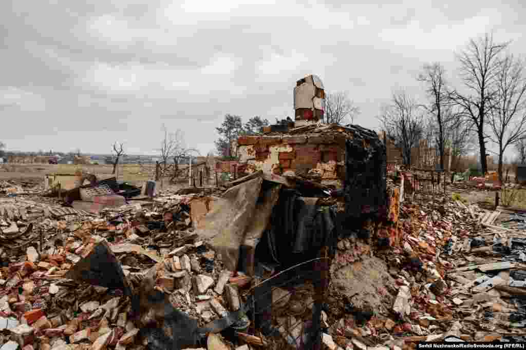 Знищені обстрілами будинки у селі Підгайне, що на Київщині. Березень 2022 року / Станом на березень 2024 року зруйновані будинки розчистили. У обійстях, куди повернулися місцеві жителі, встановили модульні будинки