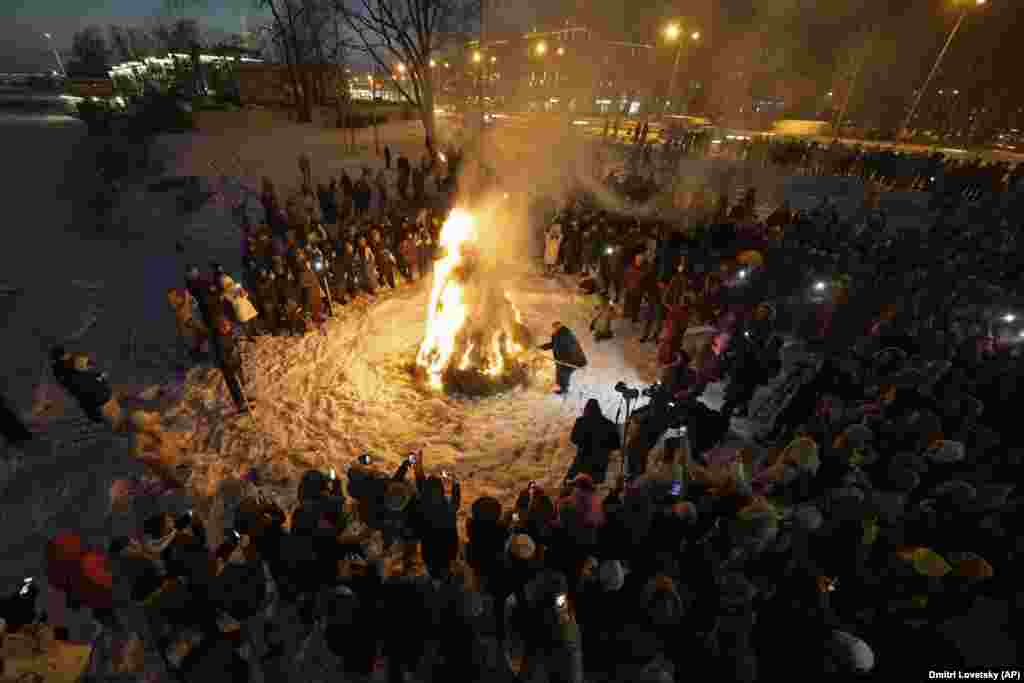 Russian believers gather around a ritual bonfire during a Buddhist ritual of purification near the Datsan Gunzechoinei temple in St. Petersburg, Russia.