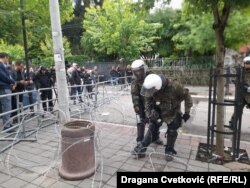 KFOR-katonák húznak ki szögesdrótot egy önkormányzati épület elé Zvečanban 2023. május 31-én