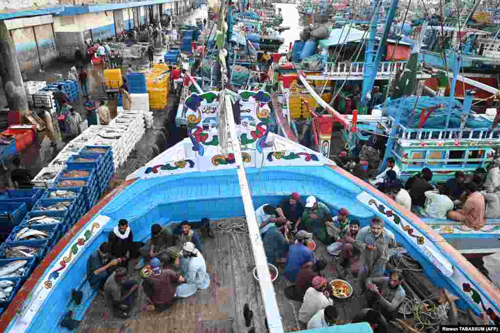 Ribari prekidaju ramazanski post na palubama brodova u luci u Karačiju, Pakistan.