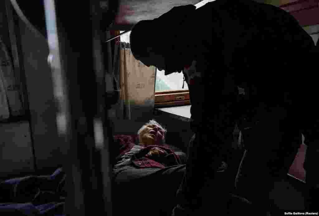 A volunteer helps an elderly woman board a train to Dnipro during an evacuation effort in Pokrovsk, Donetsk region, Ukraine, on May 10.