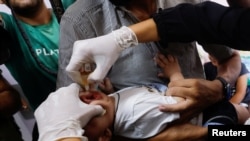 În imagine, un copil în timpul vaccinării împotriva poliomielitei, la spitalul Nasser din Khan Younis, sâmbătă, cu o zi înainte de începerea oficială a campaniei de vaccinare 