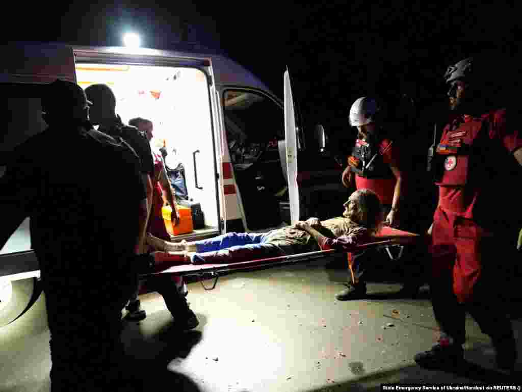 Медики несуть поранену жінку, яка постраждала після обстрілу Миколаєва. За даними ОВА, внаслідок атаки РФ у місті постраждали 19 людей, з них п&#39;ятеро дітей